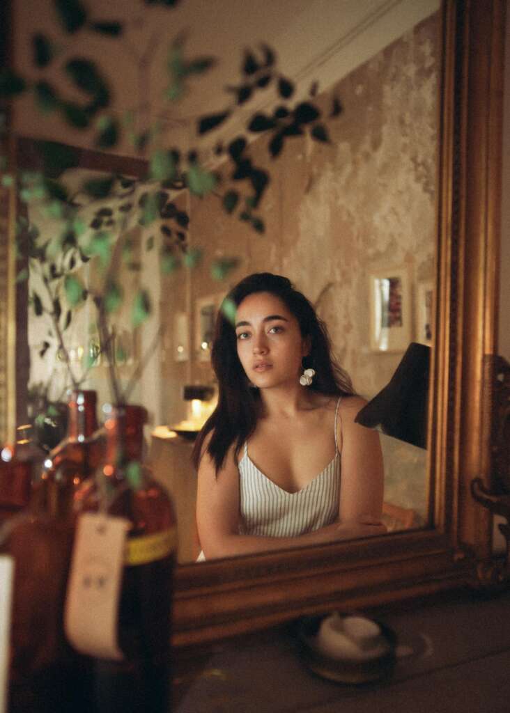 Woman looking at herself in mirror.