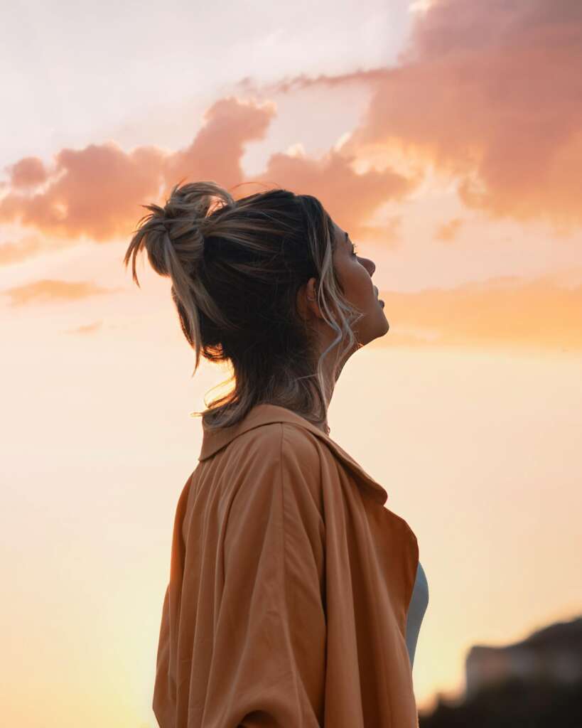 Woman looking at sunset sky.